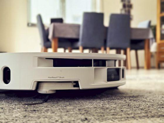 Mova S70 Roller Saugroboter mit ausgefahrener MaxiReach-Bürste vor Esstisch