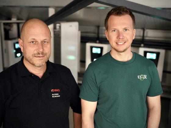 Alfred Elskamp (Dirks Bedachungen) und Tarik Guss (E3/DC) vor den neuen one-Hauskraftwerken des Hofs Hörnemann. Foto: E3/DC